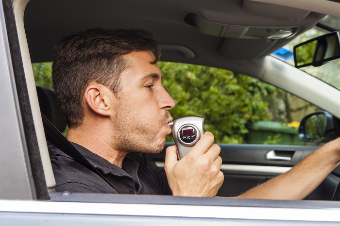 Man Blowing Into Ignition Interlock Device